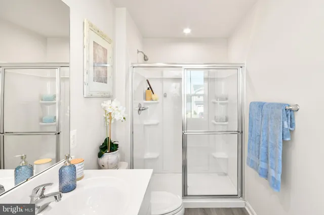 a bathroom with a granite countertop shower a sink and a mirror