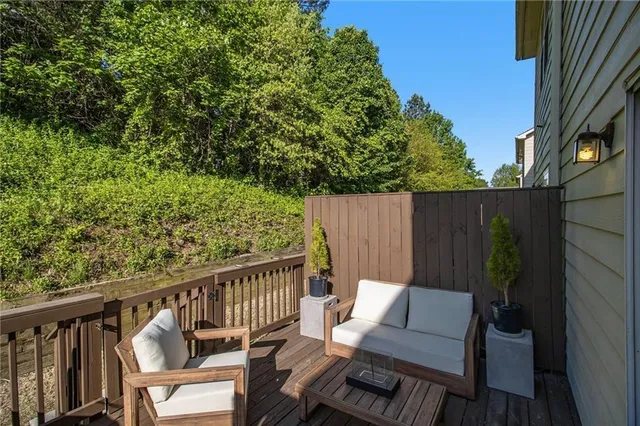 a view of a balcony with wooden floor and outdoor seating