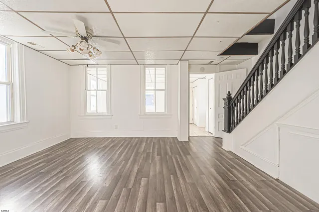 a view of a room with wooden floors and window