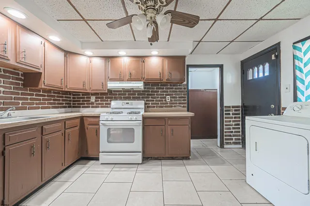a kitchen with a stove sink and cabinets