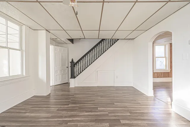 en empty room with wooden floor and windows