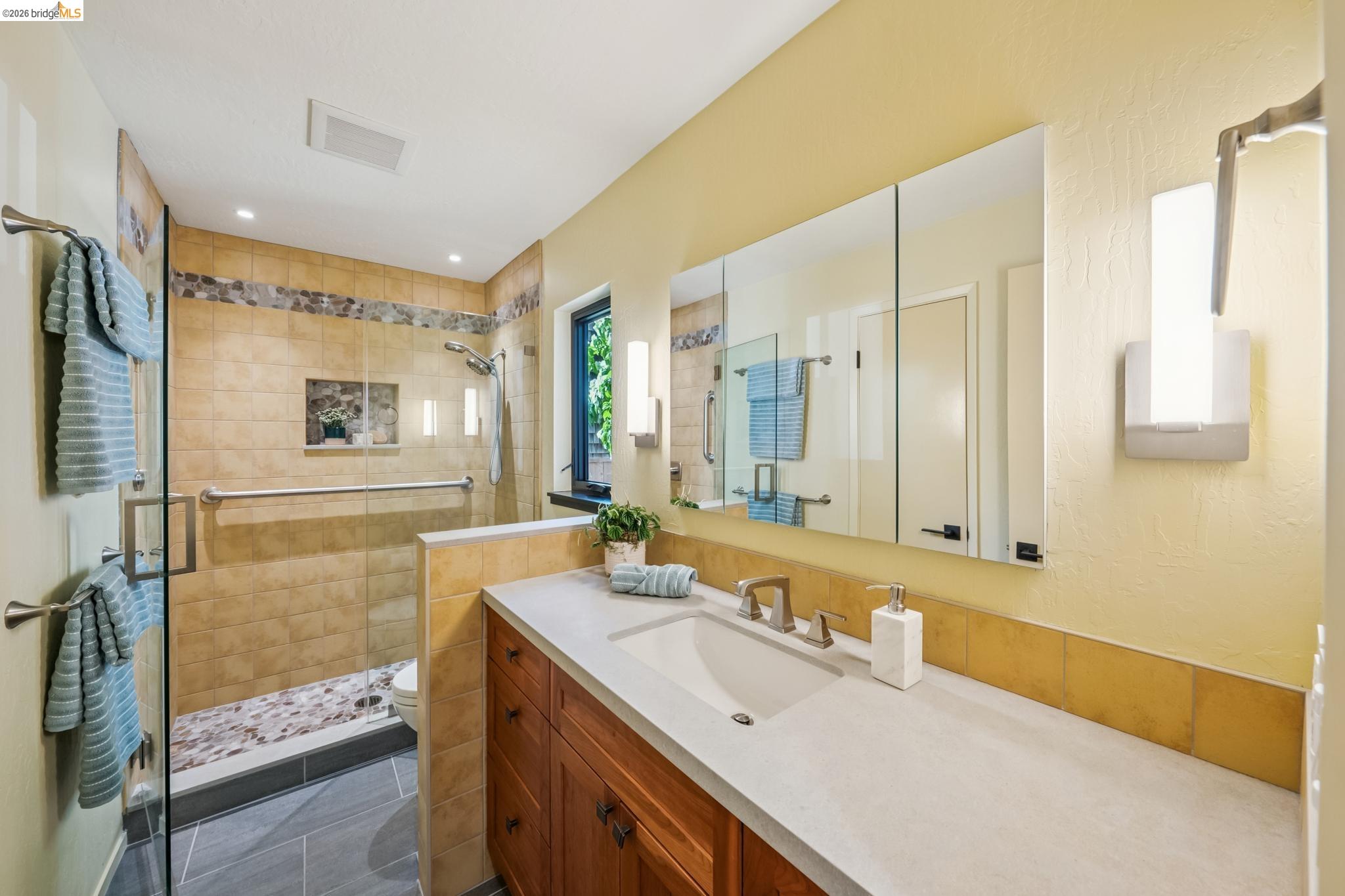 576 Vistamont Avenue Berkeley, CA 94708 - Photo 28 of 33 Contemporary bathroom featuring a spacious walk-in shower with stone tile, glass enclosure, and a pebble-tiled floor