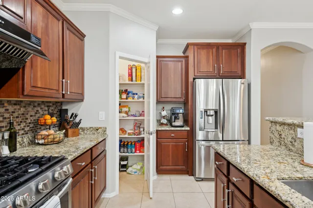 a kitchen with stainless steel appliances granite countertop a sink a stove and a refrigerator