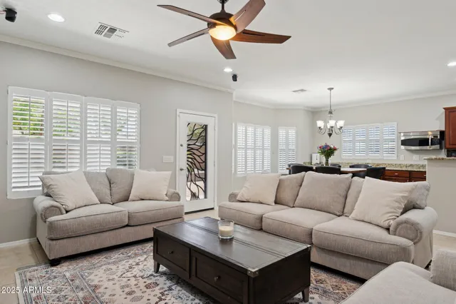 a living room with furniture kitchen view and a chandelier