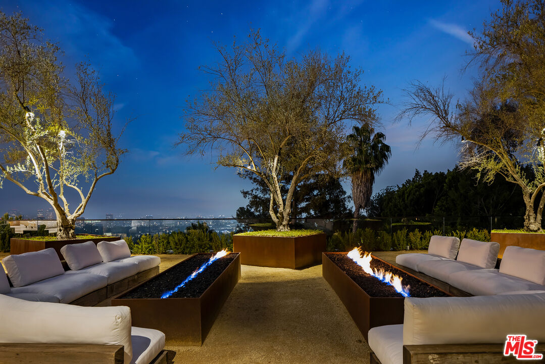 755 Sarbonne Road Los Angeles, CA 90077 - Photo 24 of 24 a view of patio with couches table and chairs under an umbrella with a fire pit
