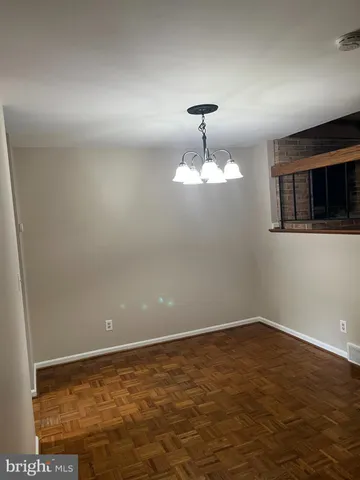 a view of an empty room with a chandelier fan
