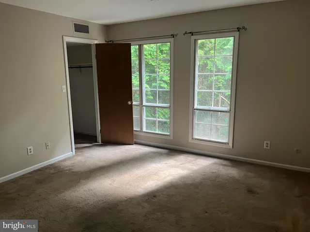 an empty room with windows and closet