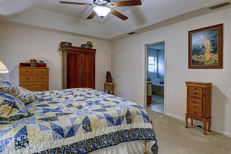 97127 Castle Ridge Drive Yulee, FL 32097 - Photo 12 of 24 a bedroom with a bed and a dresser