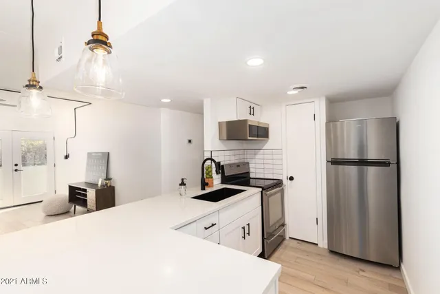 a kitchen with stainless steel appliances a refrigerator sink and cabinets