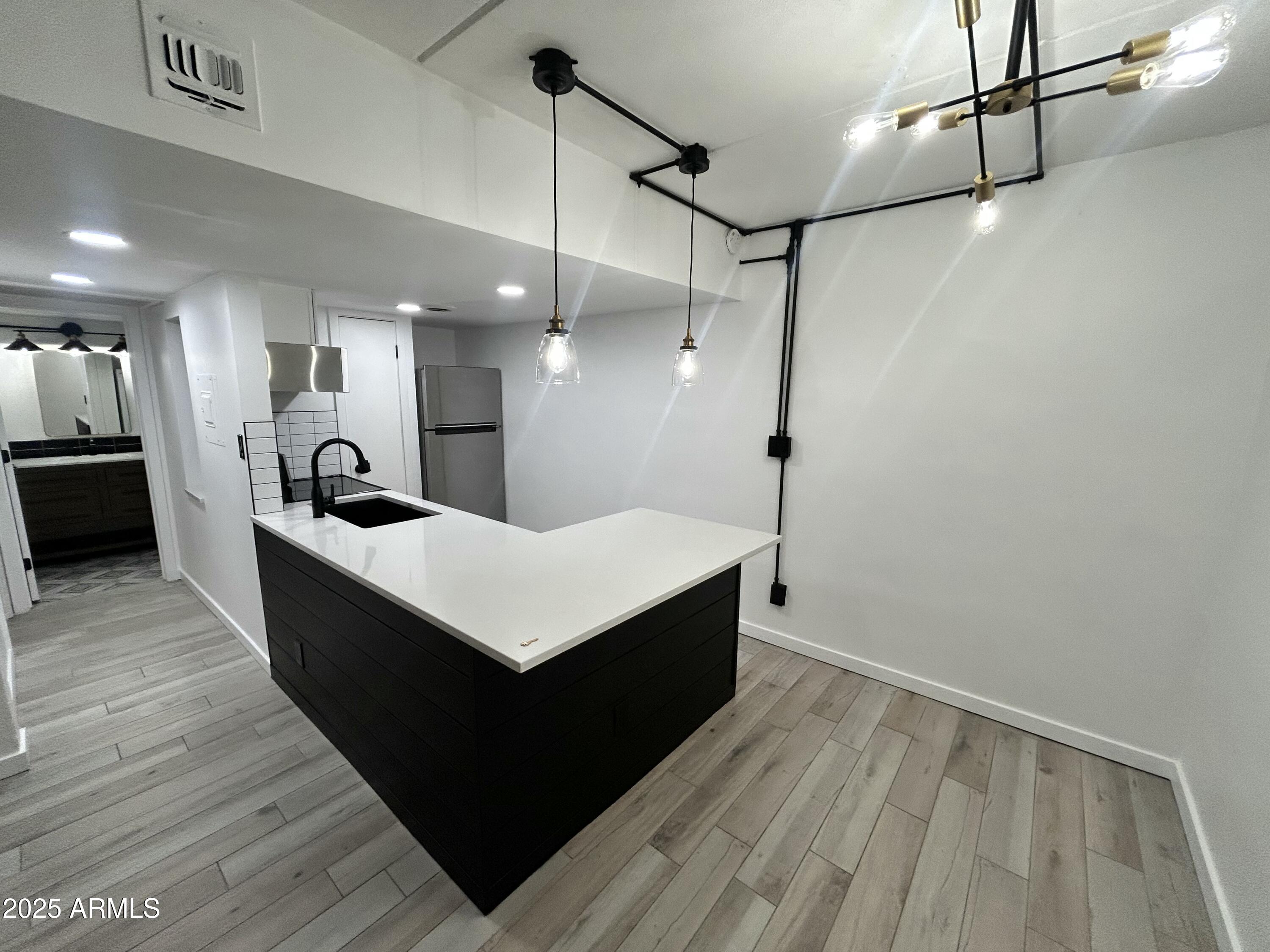 3416 North 44th Street, Unit 34 Phoenix, AZ 85018 - Photo 2 of 41 a large white kitchen with wooden floor