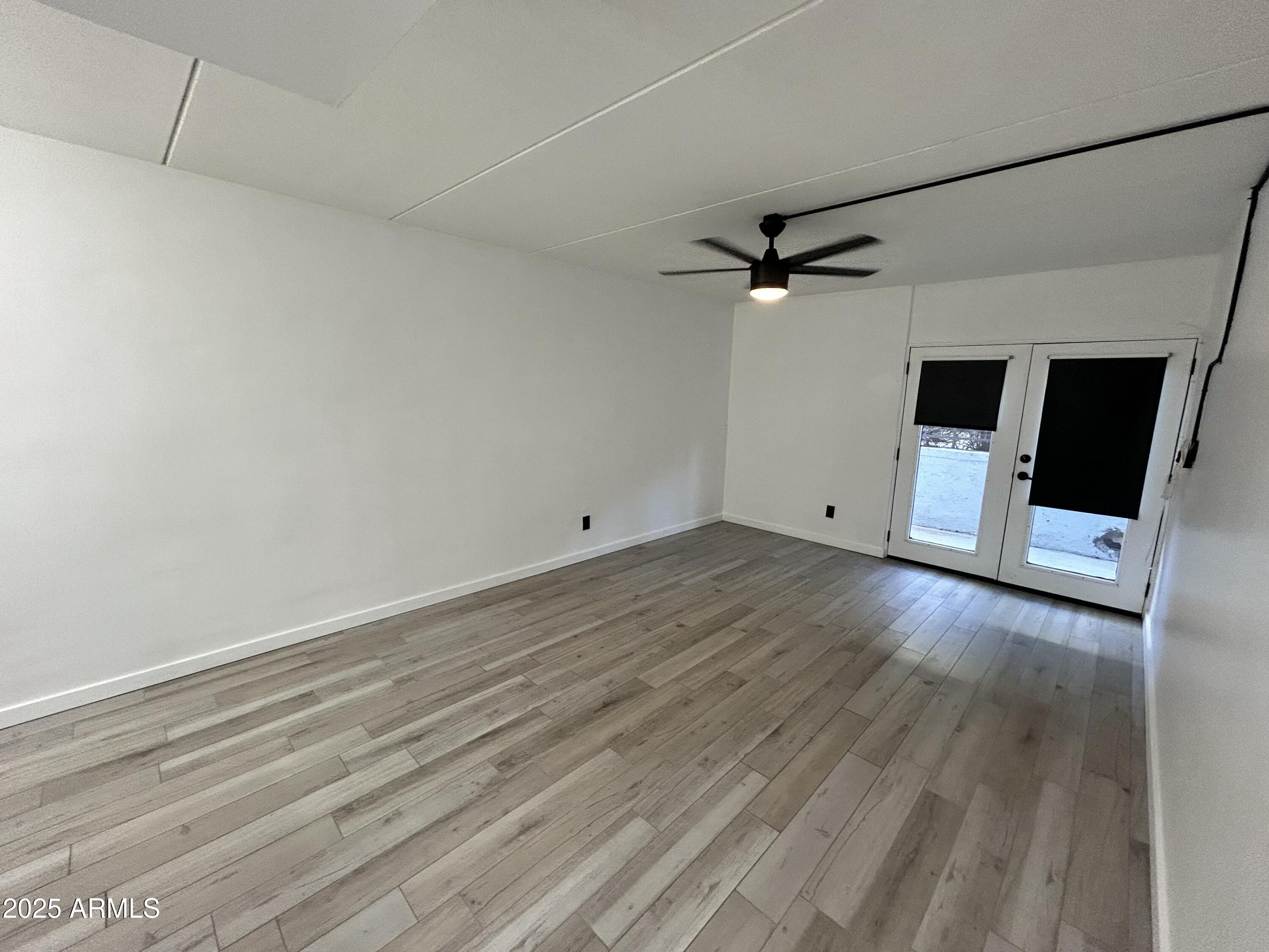 3416 North 44th Street, Unit 34 Phoenix, AZ 85018 - Photo 40 of 41 an empty room with wooden floor and a ceiling fan