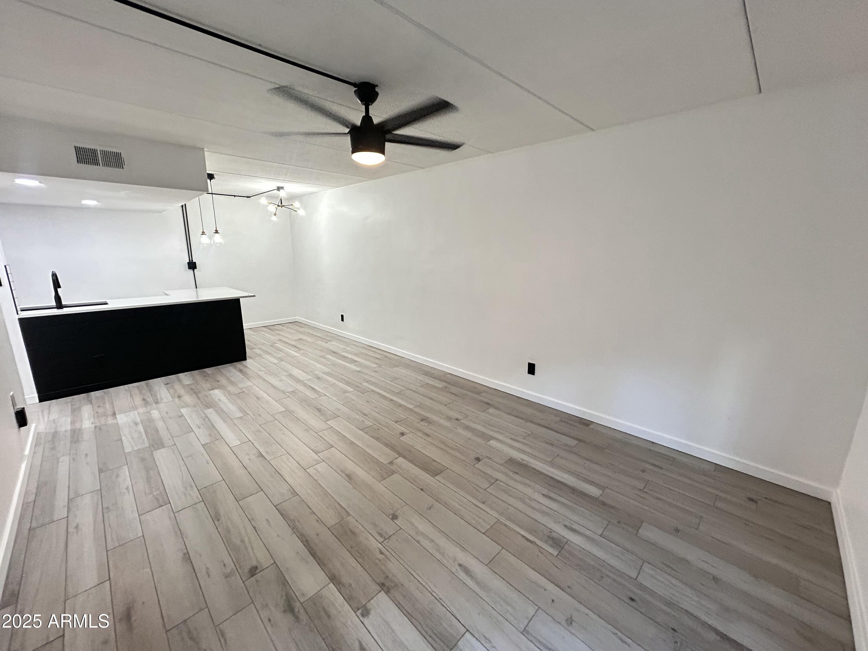 3416 North 44th Street, Unit 34 Phoenix, AZ 85018 - Photo 5 of 41 a room with wooden floor and windows