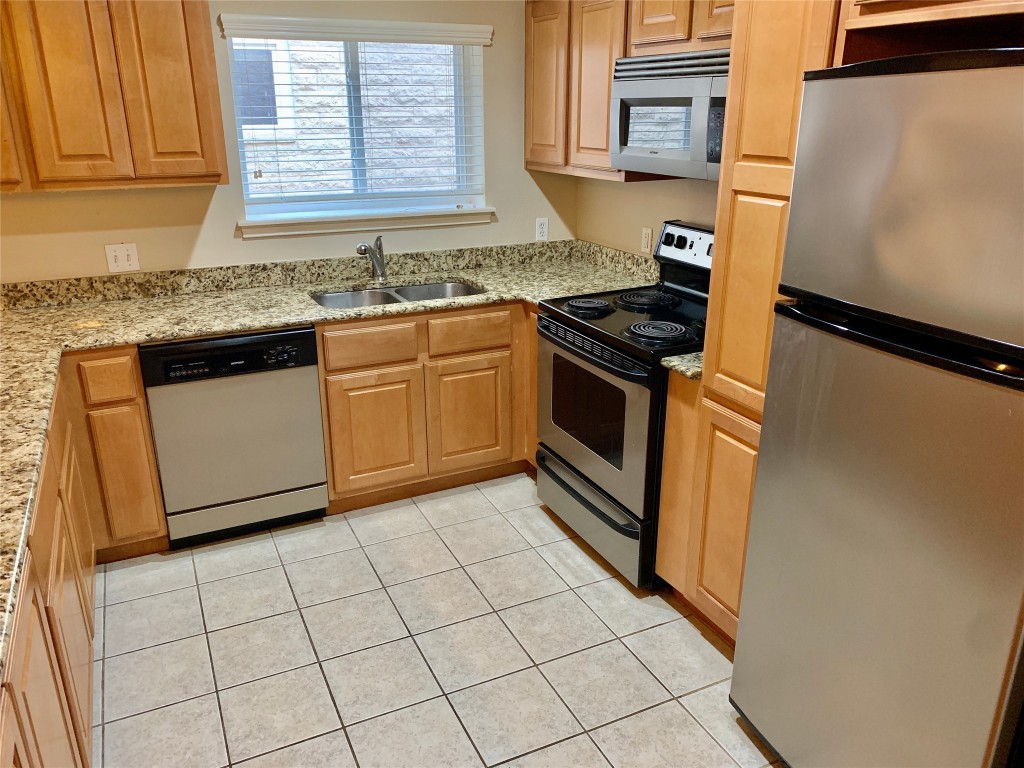3009 Speedway, Unit 4 Austin, TX 78705 - Photo 4 of 15 a kitchen with granite countertop a sink stove and cabinets
