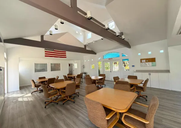 a living room with furniture kitchen view and a wooden floor