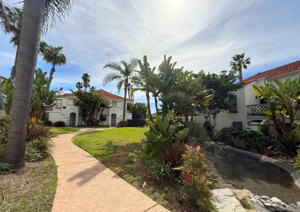 a front view of a house with a yard and potted plants