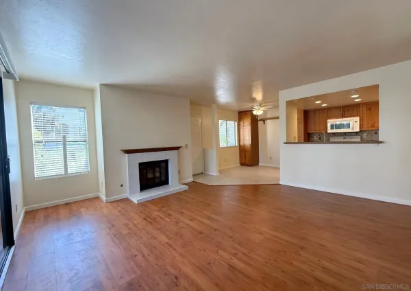 wooden floor fireplace and windows in an empty room