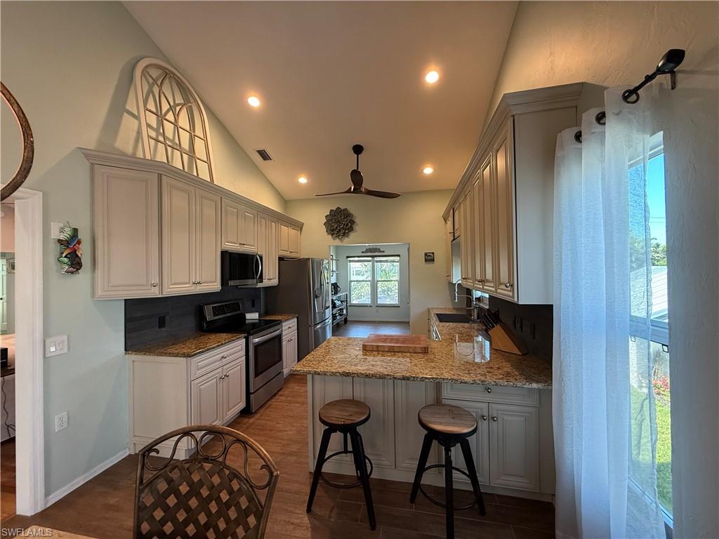 5546 Park Road Fort Myers, FL 33908 - Photo 5 of 33 a kitchen with granite countertop a stove a refrigerator and wooden cabinets