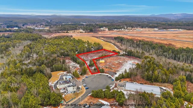 an aerial view of residential houses with outdoor space and ocean