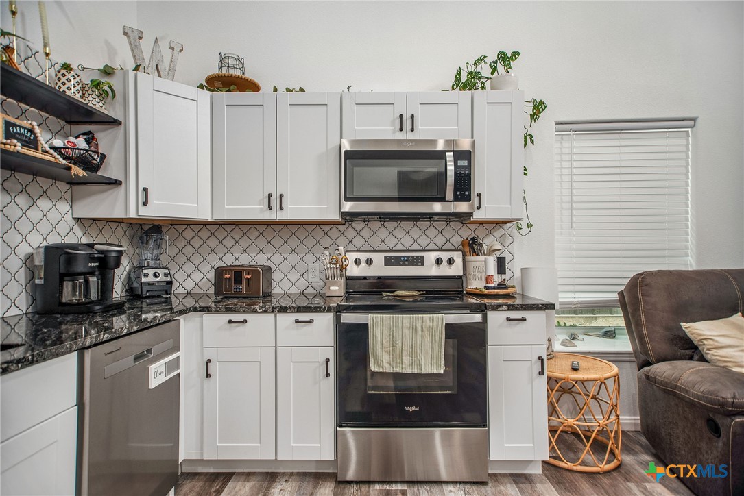 807 Dallas Avenue Seadrift, TX 77983 - Photo 13 of 35 a kitchen with stainless steel appliances granite countertop a stove a sink and a microwave