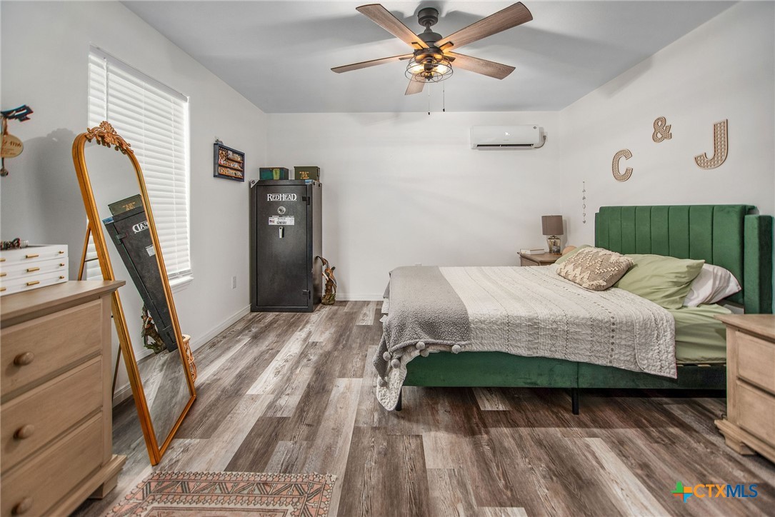 807 Dallas Avenue Seadrift, TX 77983 - Photo 20 of 35 a bedroom with a bed a dresser with wooden floor