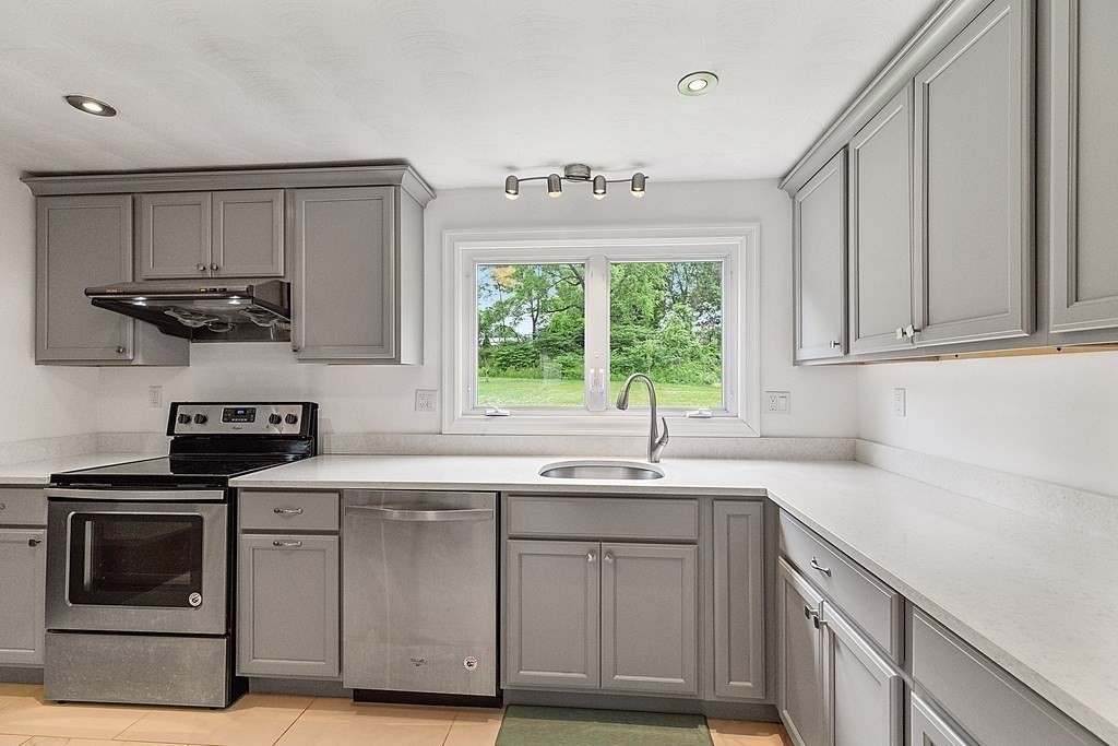 8 Winifred Road Framingham, MA 01701 - Photo 11 of 40 a kitchen with stainless steel appliances granite countertop a sink a stove a microwave and wooden cabinets