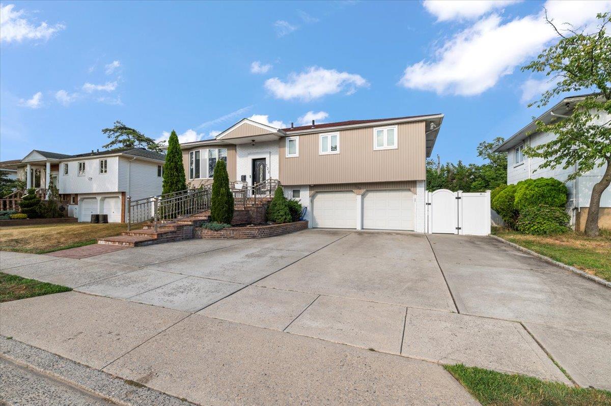 722 Eagle Drive Valley Stream, NY 11581 - Photo 2 of 35 a view of a house with a yard and garage