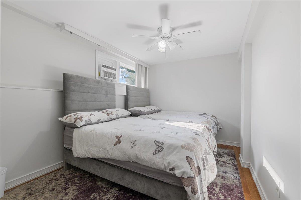 722 Eagle Drive Valley Stream, NY 11581 - Photo 24 of 35 a bedroom with a bed and a chandelier