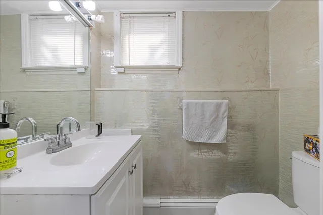 a bathroom with a sink toilet and mirror