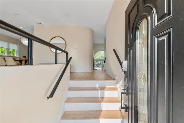 a view of staircase with lots of frames on wall and a window