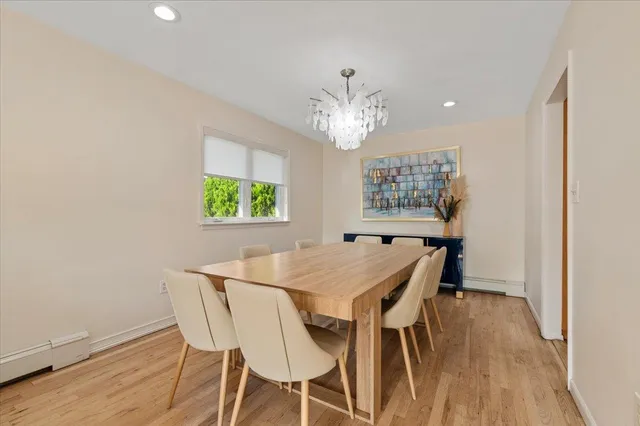 a view of a dining room with furniture a chandelier and wooden floor