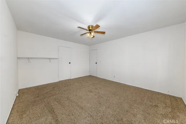 an empty room with a window and a ceiling fan