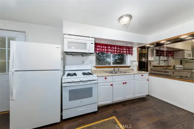 a kitchen with white cabinets and white appliances