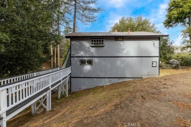 a view of backyard with wooden fence and large trees