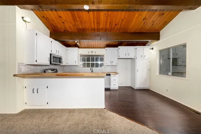 a view of kitchen with stainless steel appliances granite countertop lots of counter top space and cabinets