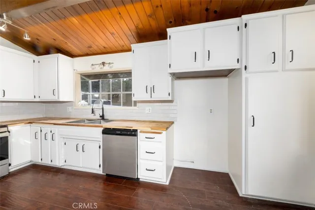 a kitchen with stainless steel appliances granite countertop a sink and cabinets with wooden floor