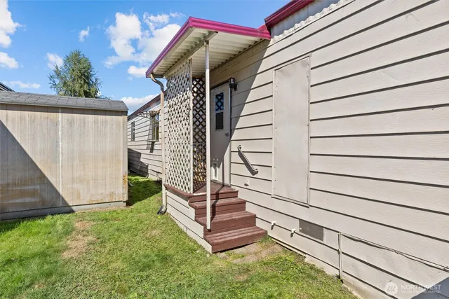 a view of a house with table and chairs in a yard