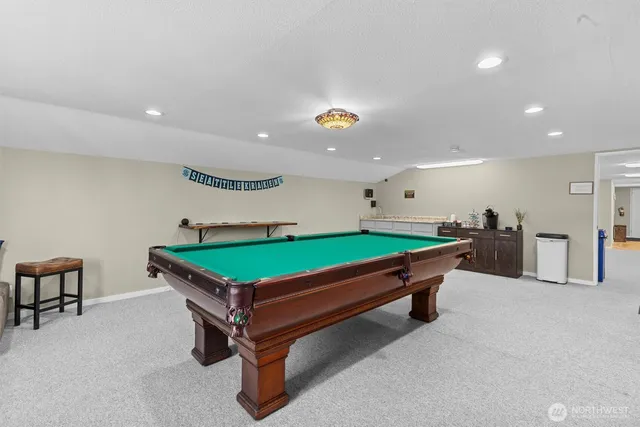 a room with furniture pool table and windows
