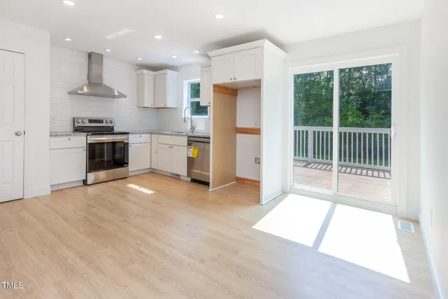 a large kitchen with a large window and stainless steel appliances