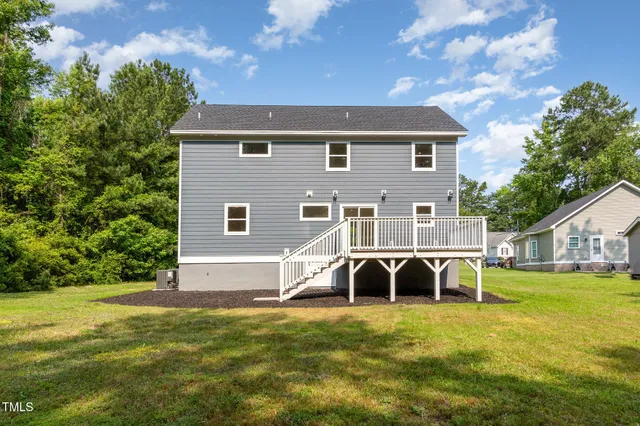 a view of a house with a big yard and a large tree