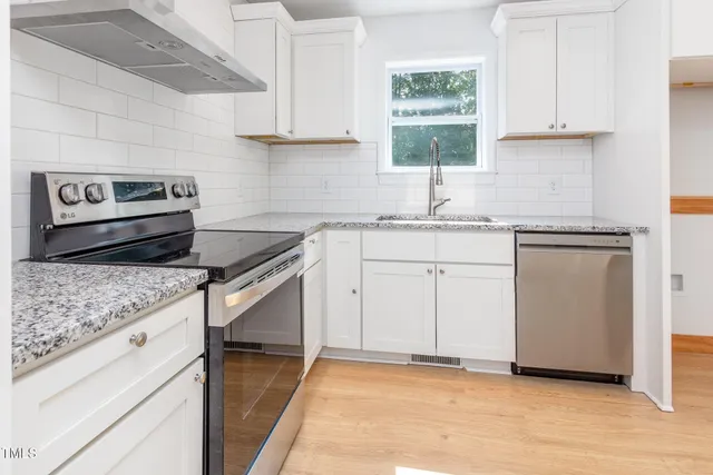 a kitchen with cabinets appliances and a window