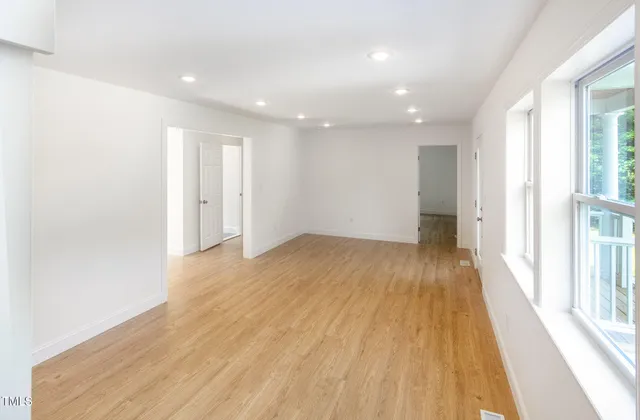 a view of wooden floor in an empty room with a window