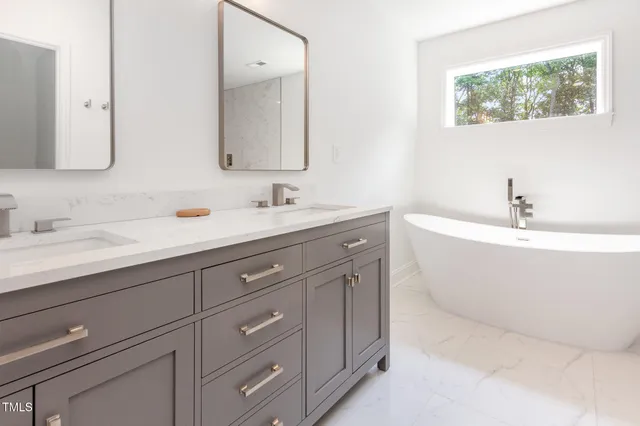 a bathroom with a bathtub a sink and mirror