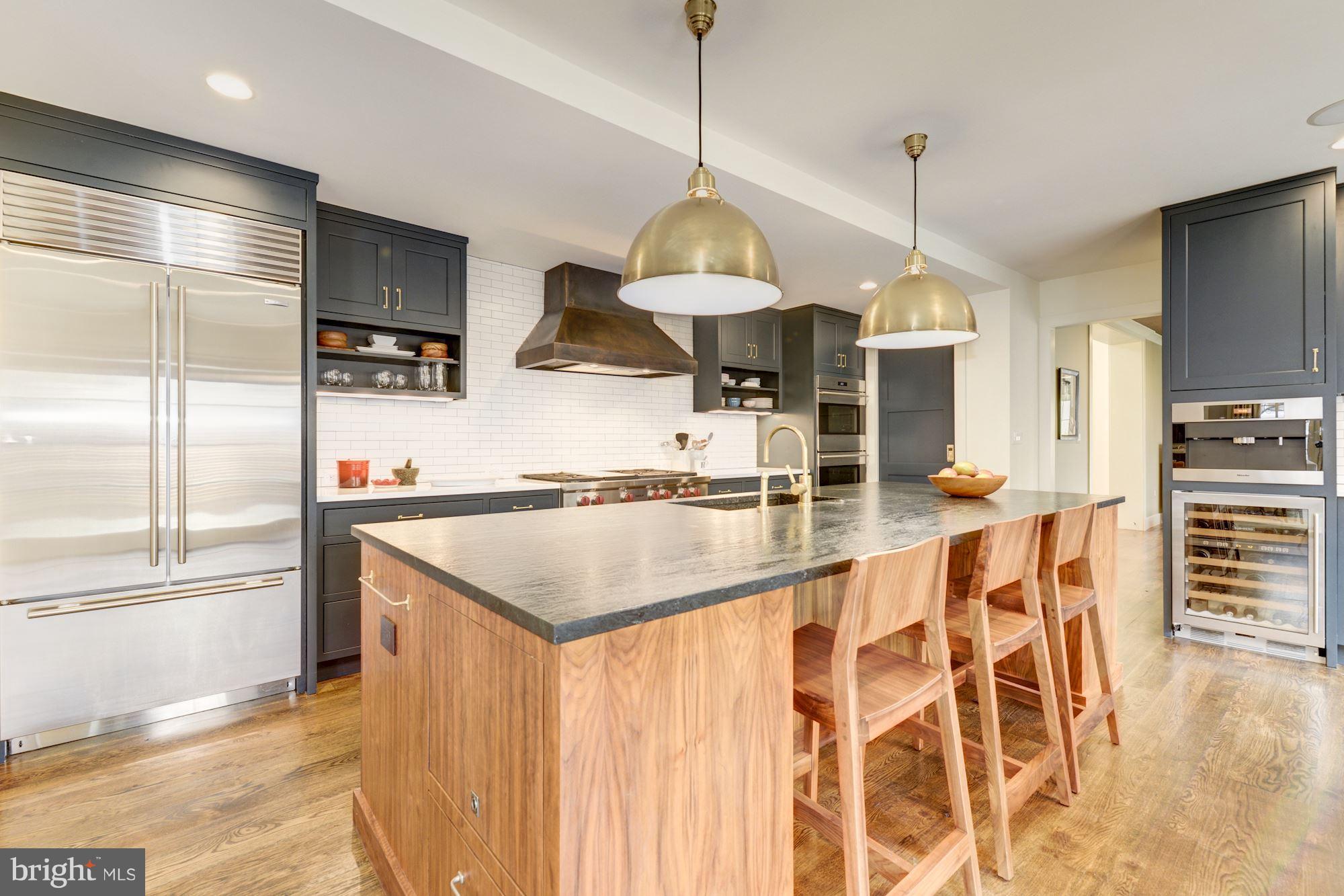 6134 Nevada Avenue Chevy Chase, MD 20815 - Photo 8 of 30 a kitchen with stainless steel appliances kitchen island granite countertop a sink and a refrigerator