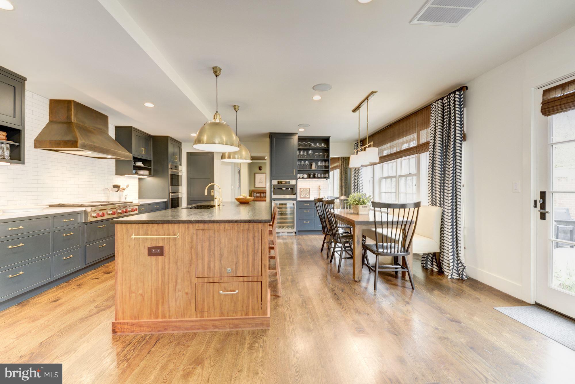 6134 Nevada Avenue Chevy Chase, MD 20815 - Photo 10 of 30 a kitchen with stainless steel appliances granite countertop wooden floor dining table and chairs