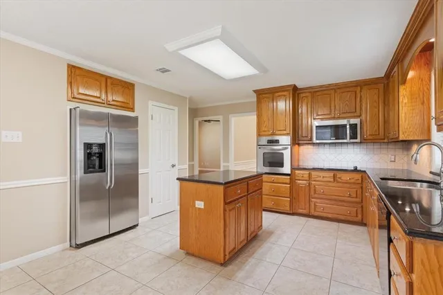 a kitchen with stainless steel appliances granite countertop a refrigerator stove and sink