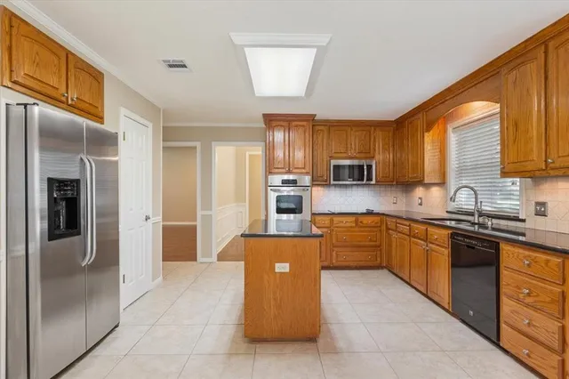 a kitchen with stainless steel appliances granite countertop a refrigerator stove top oven a sink and dishwasher