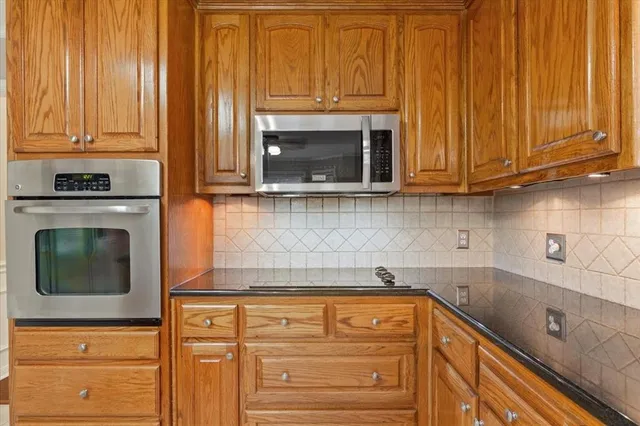 a kitchen with granite countertop cabinets and a fireplace