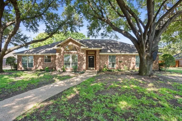 a front view of a house with yard and green space
