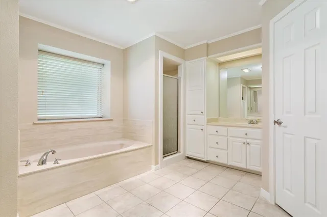 a spacious bathroom with a tub sink and mirror