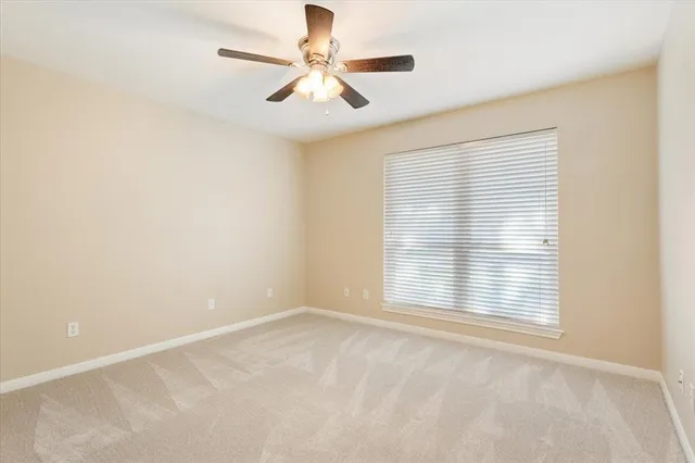 an empty room with a window and a fan